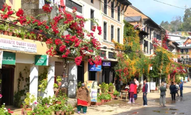 Traditional street in Bandipur Nepal with Newari houses, colorful flowers, and mountain village atmosphere