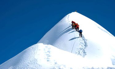 Island Peak expedition in Nepal with climbers ascending a snow and ice ridge in the Everest region of the Himalayas.